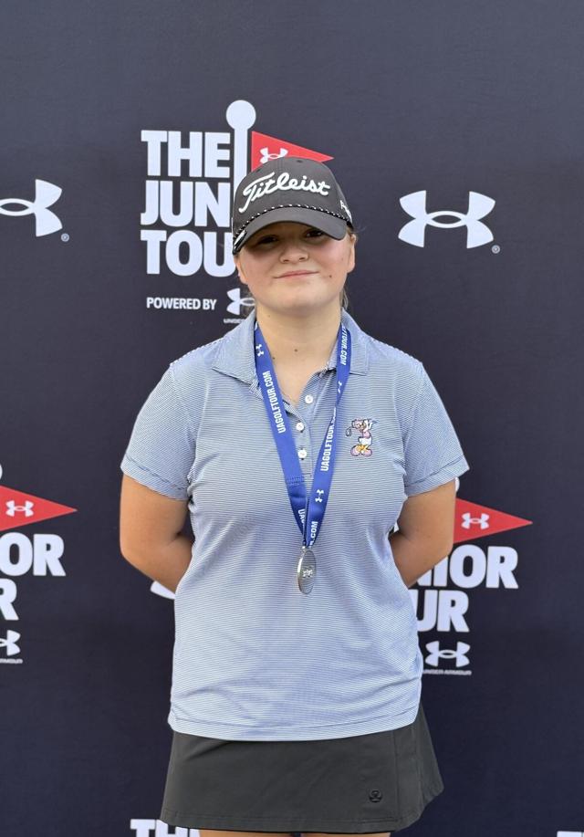 Junior Player Program student holding a medal at a junior golf tour event